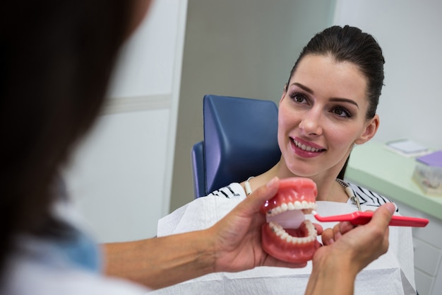 dentist-showing-set-model-teeth-patient_107420-65670